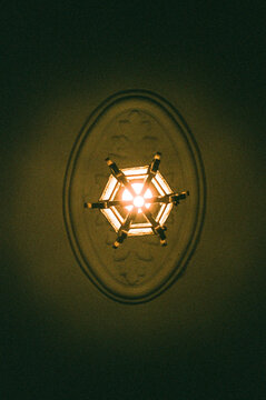 Star-shaped chandelier hanging from plaster ceiling