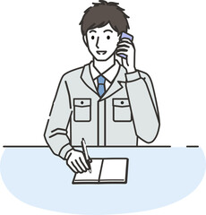 電話しながらメモをとる作業服を着た男性