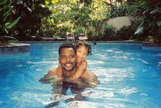A father with his toddler swimming in the pool