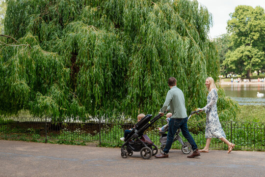 Couple with strollers taking their two children for a walk 