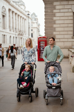 Couple with strollers taking their two children for a walk 