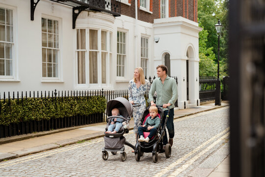 Couple with strollers taking their two children for a walk 