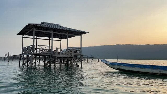 Fisherman house in the Indian Ocean Fishing boat catch grow fish fish farm Vietnam phu Quoc island. Restaurant on the water catch fish grow nets wooden house Cloudless sky and calm water