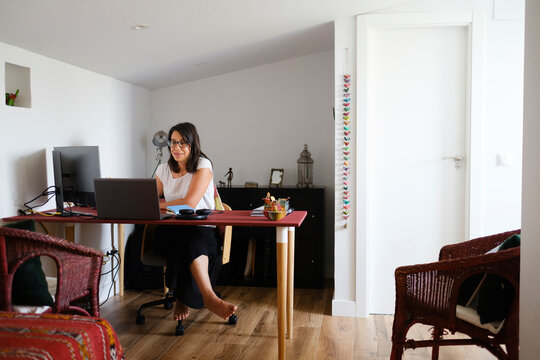 Woman working in home office in small bright room