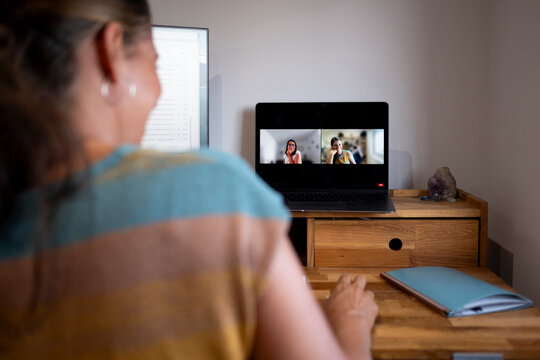 Woman video chatting from home office in high desk