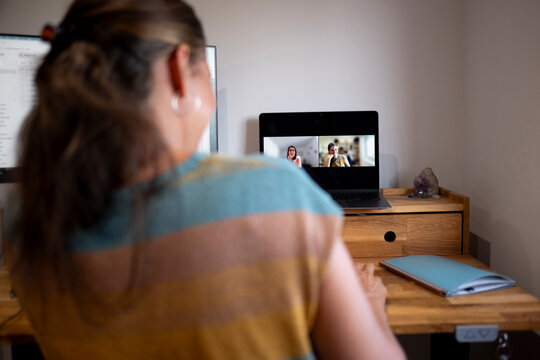 Woman chatting from home office in wooden high desk