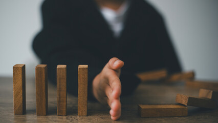 Hand-stopping domino effect. Concept of risk protection, business solution, or successful...