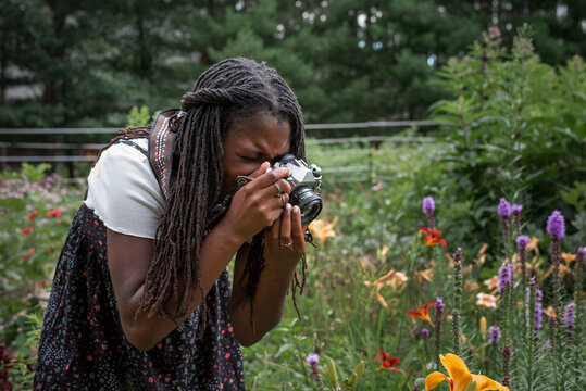 Teen girl taking photos of flowers