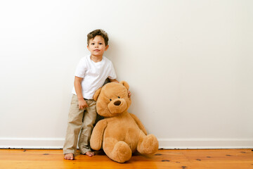 little boy playing with big teddy bear