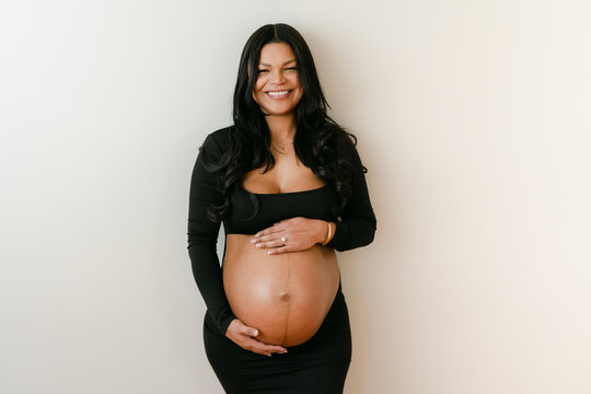 pregnant mother holding her round belly 
