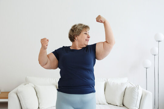 Happy plus size woman showing biceps