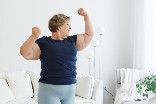 Smiling plus size woman demonstrating biceps
