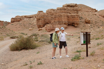 Female tourists examining map in canyon