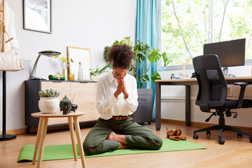 Businesswoman doing namaste gesture during meditation