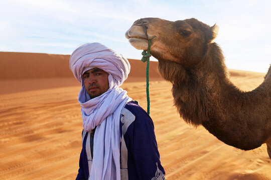 A young Berber with a camel in the Sahara Desert.