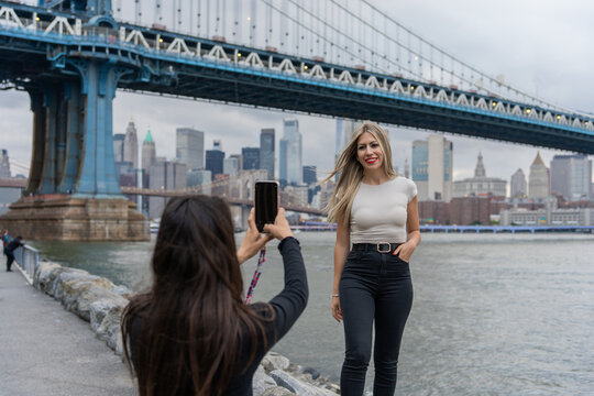 Two Tourist Girls Taking Photos In Brooklyn, New York.