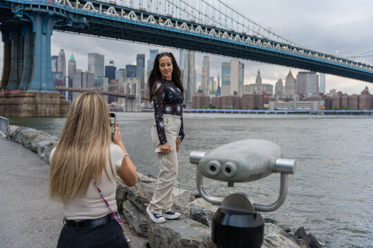 Two Tourist Girls Taking Photos Near Manhattan Bridge New York.