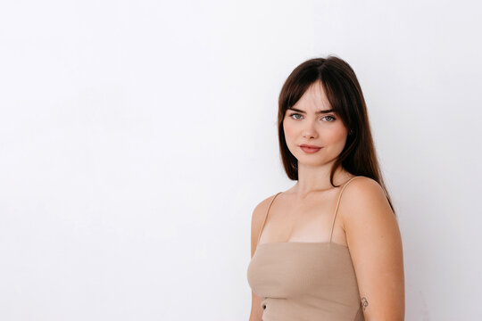 Happy woman with long hair in crop top near wall