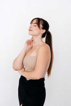 Dreamy young sensual woman with crossed arm in studio