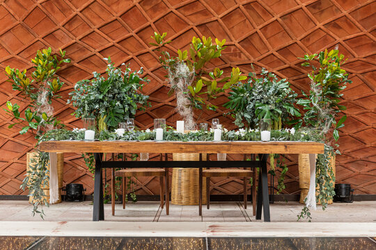 A wooden table adorned with lamps and floral arrangements