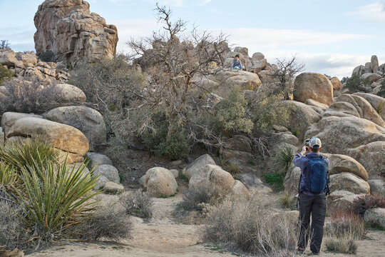 A father takes a picture of his son in Joshua Tree National Park