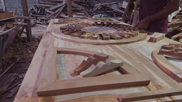 Artisan woodworking intricate wooden design in progress at a carpenter workshop with tools and wood pieces in background