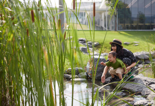 Asian mother and son, playing by the water in the garden