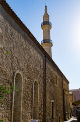 Minaret near the building against the sky