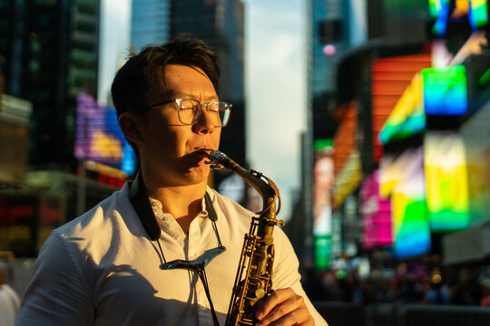 Passionate Man Playing The Saxophone On The Street At Sunset.