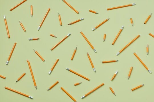 Broken pencils against green background.