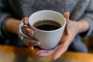 コーヒーを飲む女性の手元