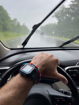 Hand watch Steering wheel driving car highway road trip rain storm 