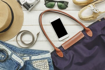 Naklejka premium Top View Accessoires Travel With Women Clothing Concept White Mobilephone Belt Bag Hat Camera Necklace Trousers Sunglasses White Wood Table