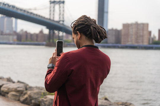 Black Man Taking A Photo Of Manhattan Bridge In New York.