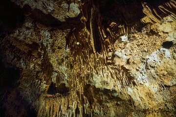 A wild cave inside. Stalactites and stalagmites. Speleology and surveys