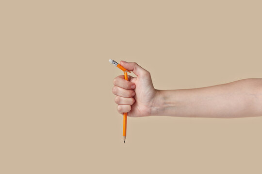 Woman's hand breaking graphite pencil.