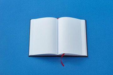 Open blank book on blue background.
