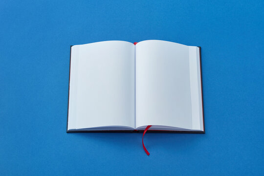 Open blank book on blue background.