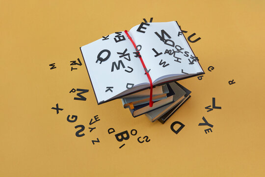 Black letters scattered around stack of books.