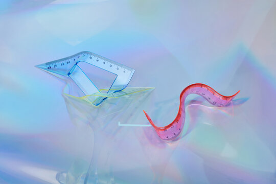 Bent rulers against iridescent background.
