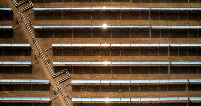 Renewables - sun flare reflection on shiny parabolic solar mirrors