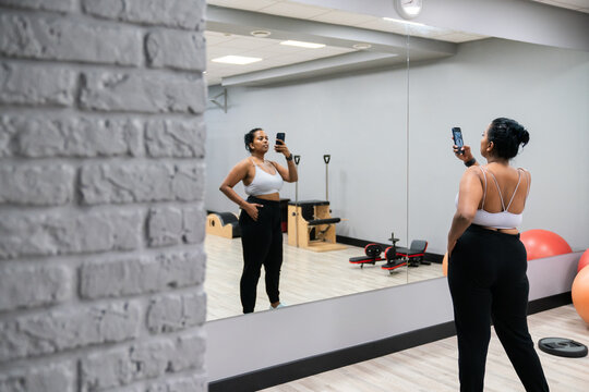 Plus Size Woman Doing Selfie In The Gym Mirror