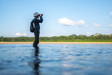 Man using binoculars in a river
