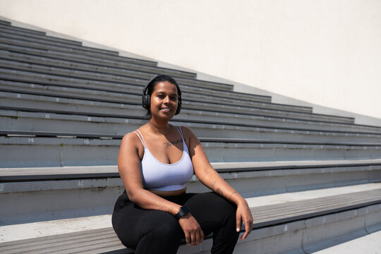 Smiling Curvy Woman Wearing Headphones Outdoors
