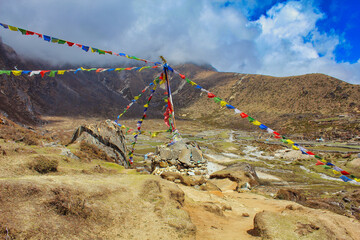 Tibetan Prayer flags near Machermo village at 4470 meters lies on the Dudh Kosi river on the Gokyo lake trails and offers accommodation for trekkers in the Khumbu, Nepal - obrazy, fototapety, plakaty