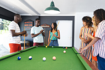 Diverse group of friends enjoys a game of pool in a home setting