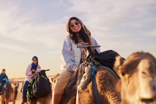A group of tourists embarks on a Sahara desert expedition at sunrise.