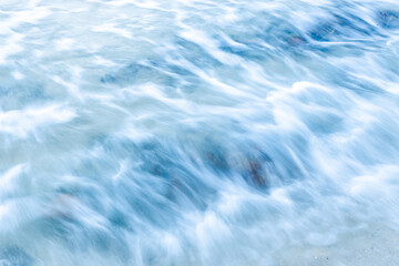 Ocean waves crash on the rocky beach.