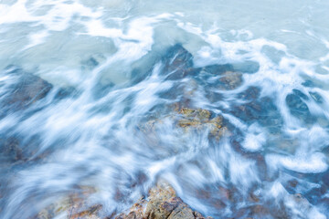 Ocean waves crash on the rocky beach.