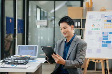 Young attractive Asian male office worker business suits smiling at camera